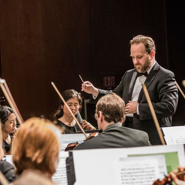 a conductor directing the performance of an orchestra