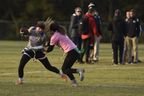 Two women playing flag football on field