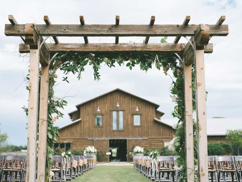 Barn with chairs set up for wedding and ceremonial arch