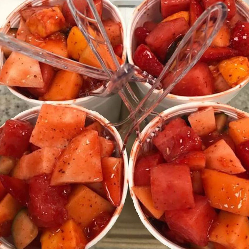 A photo of four yogurt cups topped with fresh red fruit. 