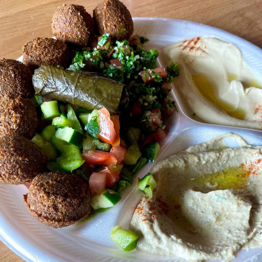 Photo of a plate with hummus and a greek salad. 