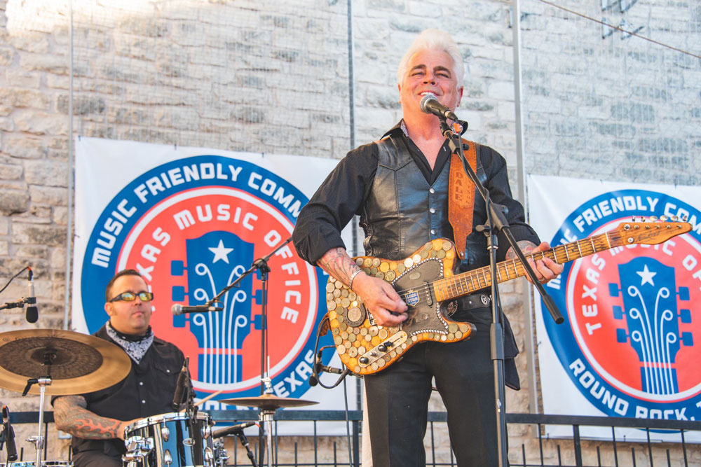 Dale Watson on stage with a drummer in the background. 