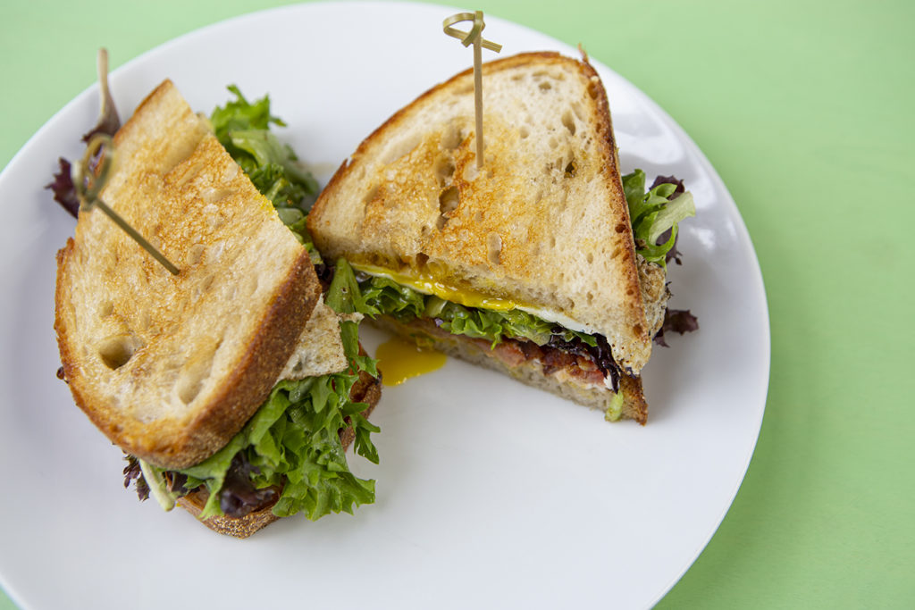 A photo of a BLT sandwich on toasted bread on a plate. 