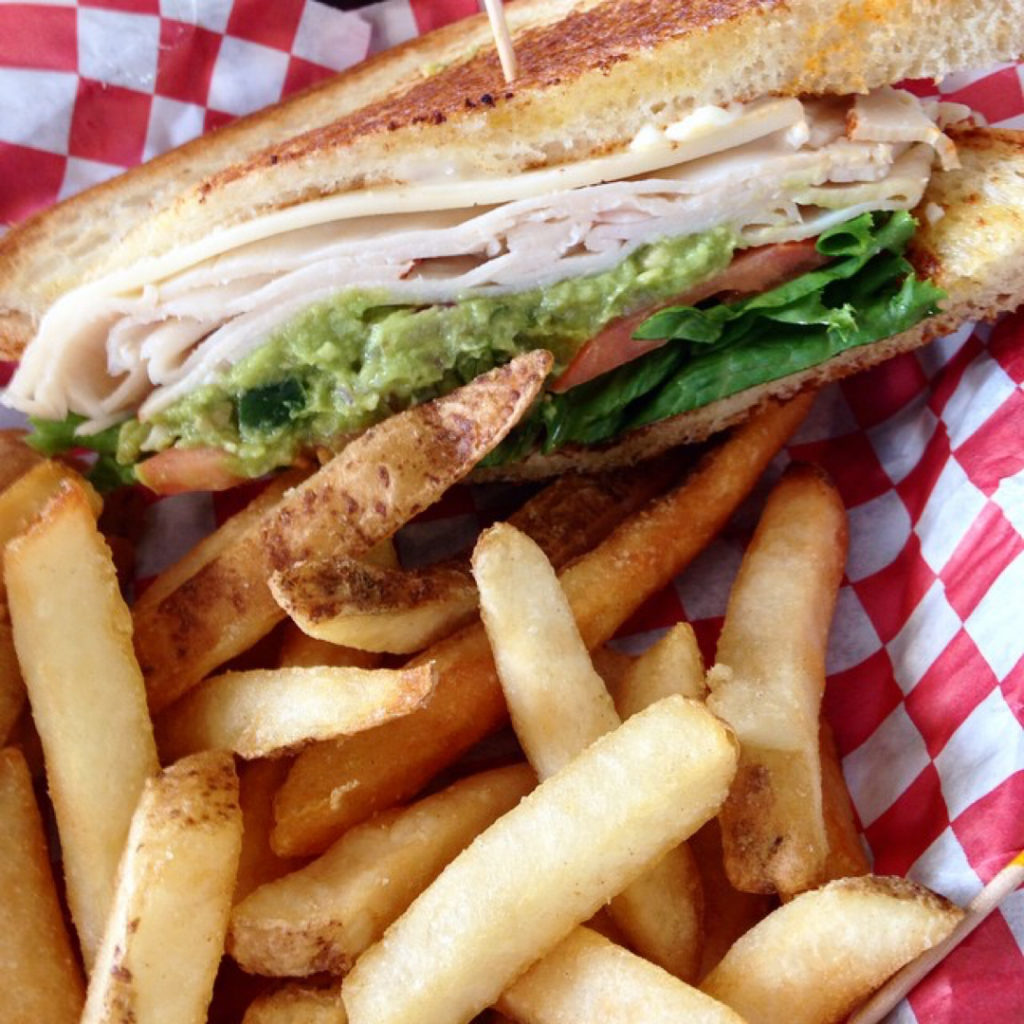 Picture of a a turkey club with fries