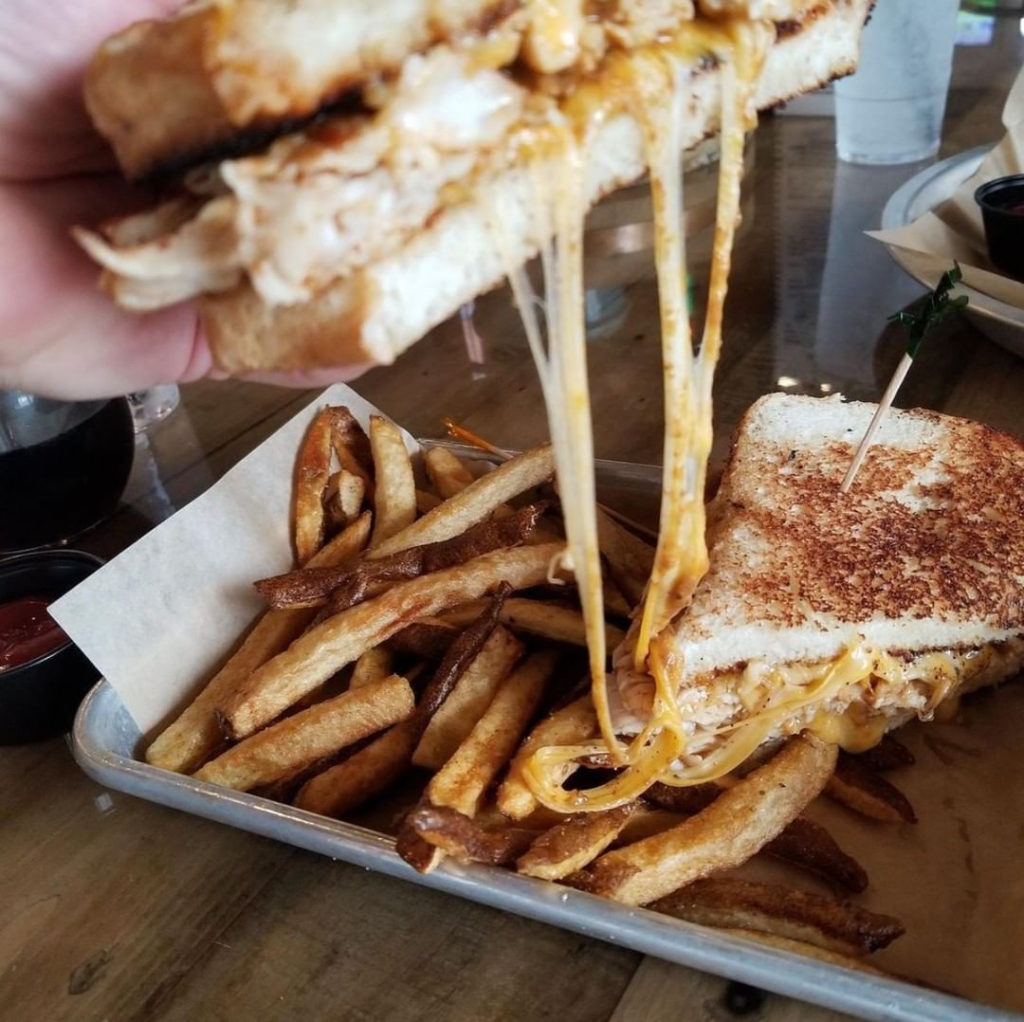Picture of a grilled cheese sandwich being pulled. 