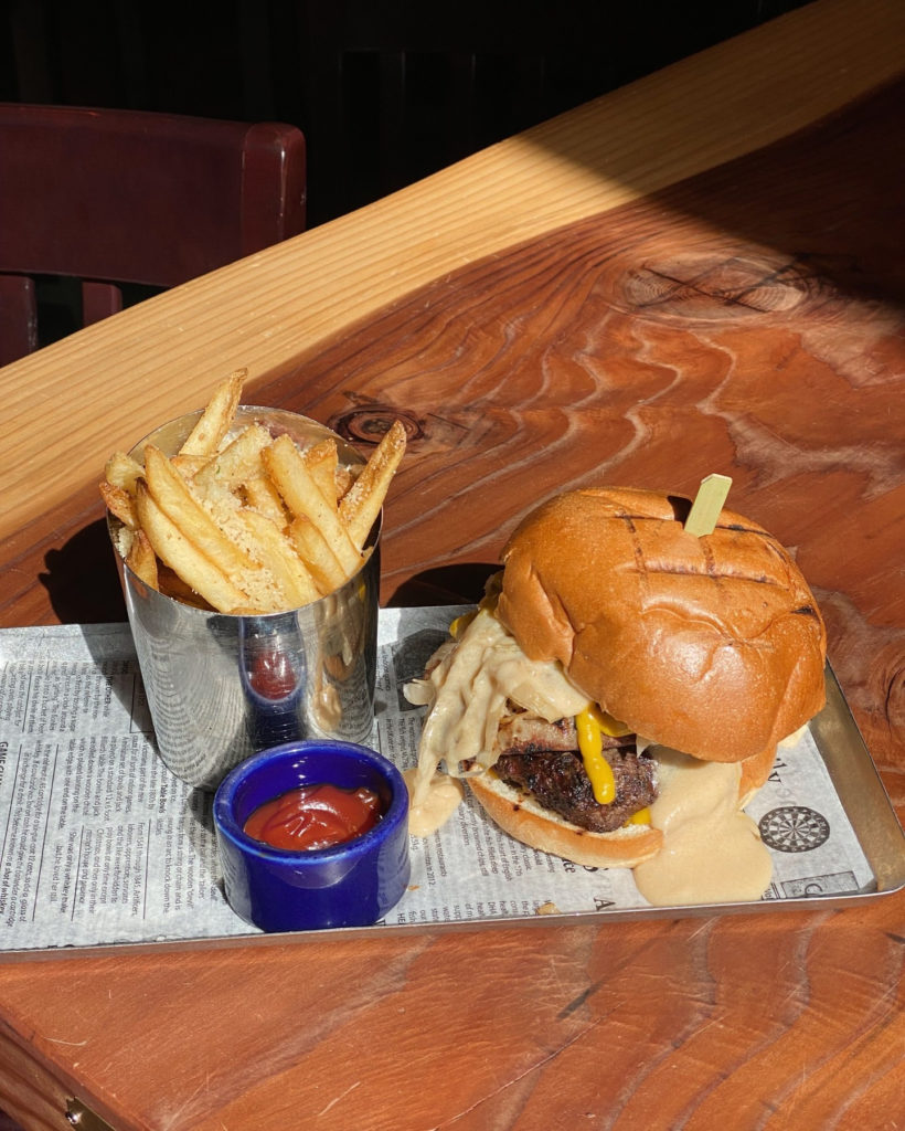 Photo of a burger and fries on a plate outside.
