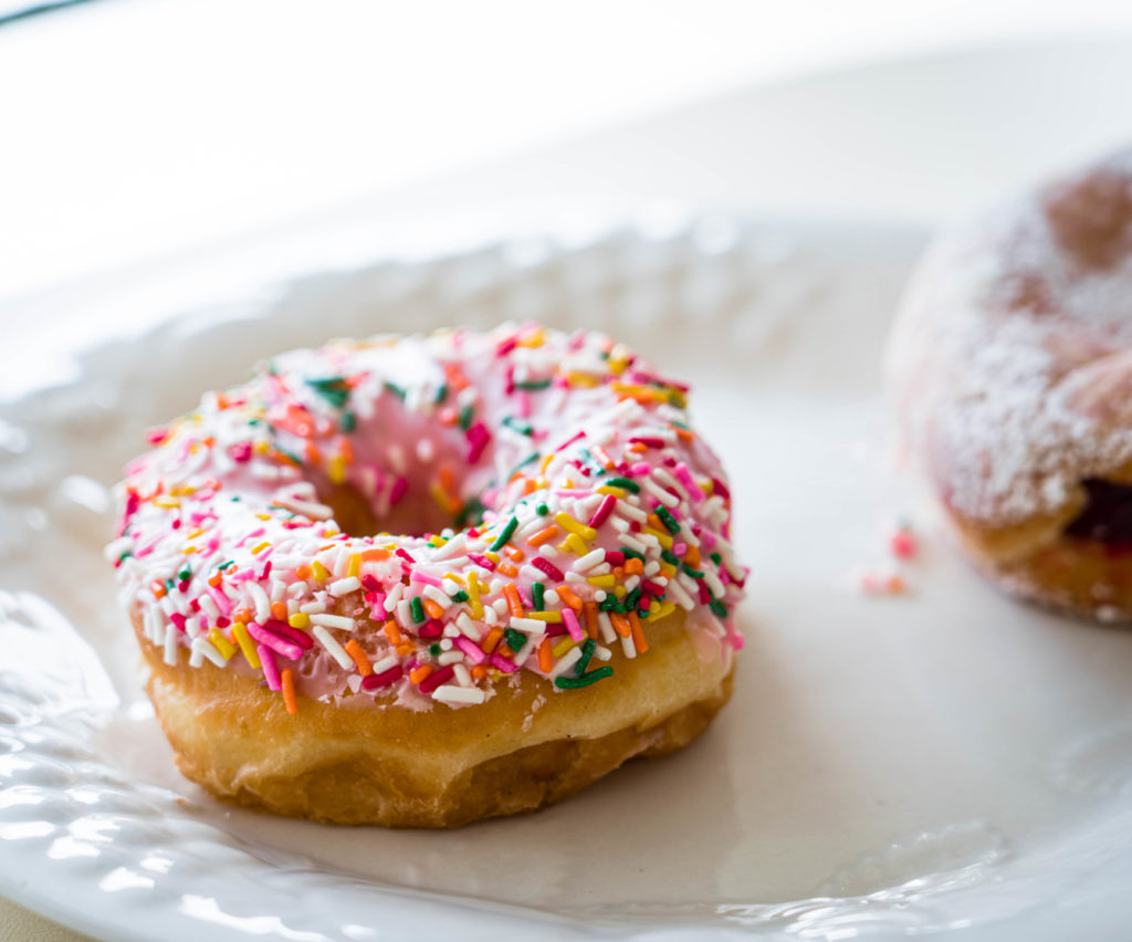 Donut with pink frosting and multi color sprinkles 