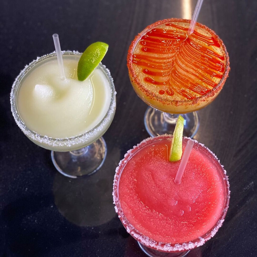 Three Margaritas on a table. 