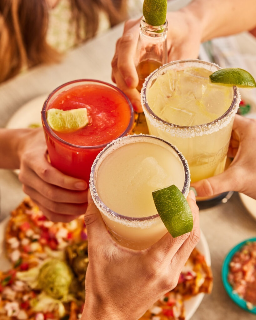 3 people holding a margarita. 