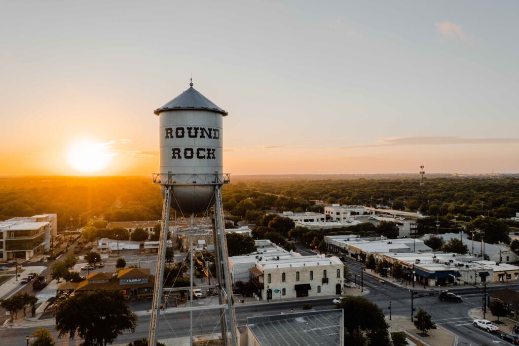 Photo of the Round Rock water tower with the sunrise in the background. 