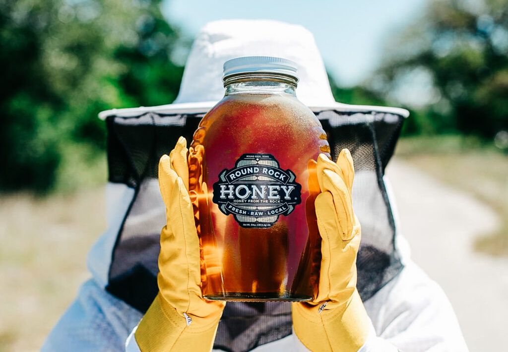 Beekeeper holding a jar.