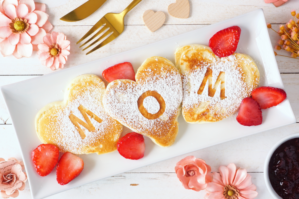 Pancakes with Mom letters on them and strawberries. 
