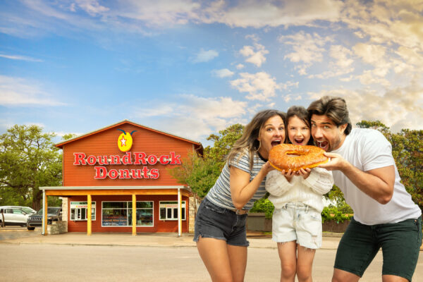 Family eating donut in front of Round Rock Donuts
