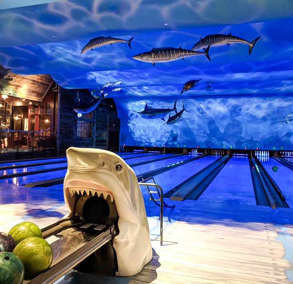 Underwater themed bowling lanes at Uncle Buck’s with ocean lighting and a shark ball return.