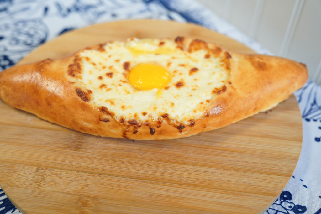 Adjaruli w/Cheese (Traditional open-faced khachapuri from the Adjara region with cheese blend, egg yolk, and butter)