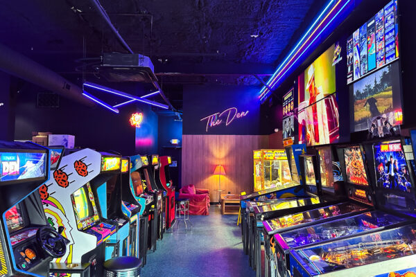 Retro arcade room at Pixel Palace with neon lights, classic games, and pinball machines.
