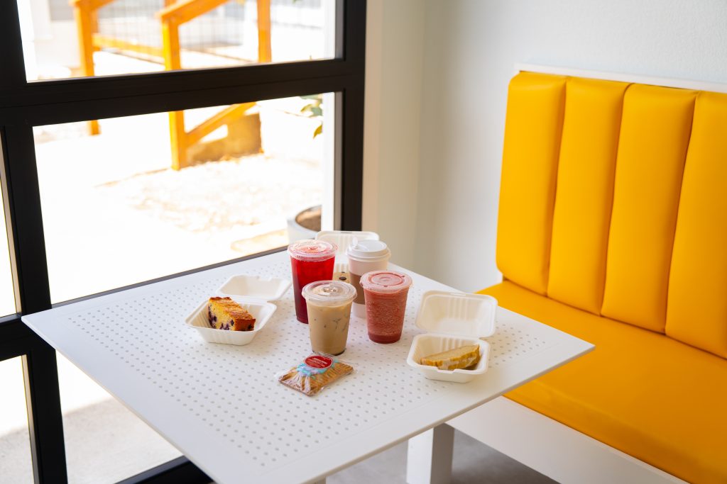 A booth and a table with assorted drinks and breakfast/lunch items.